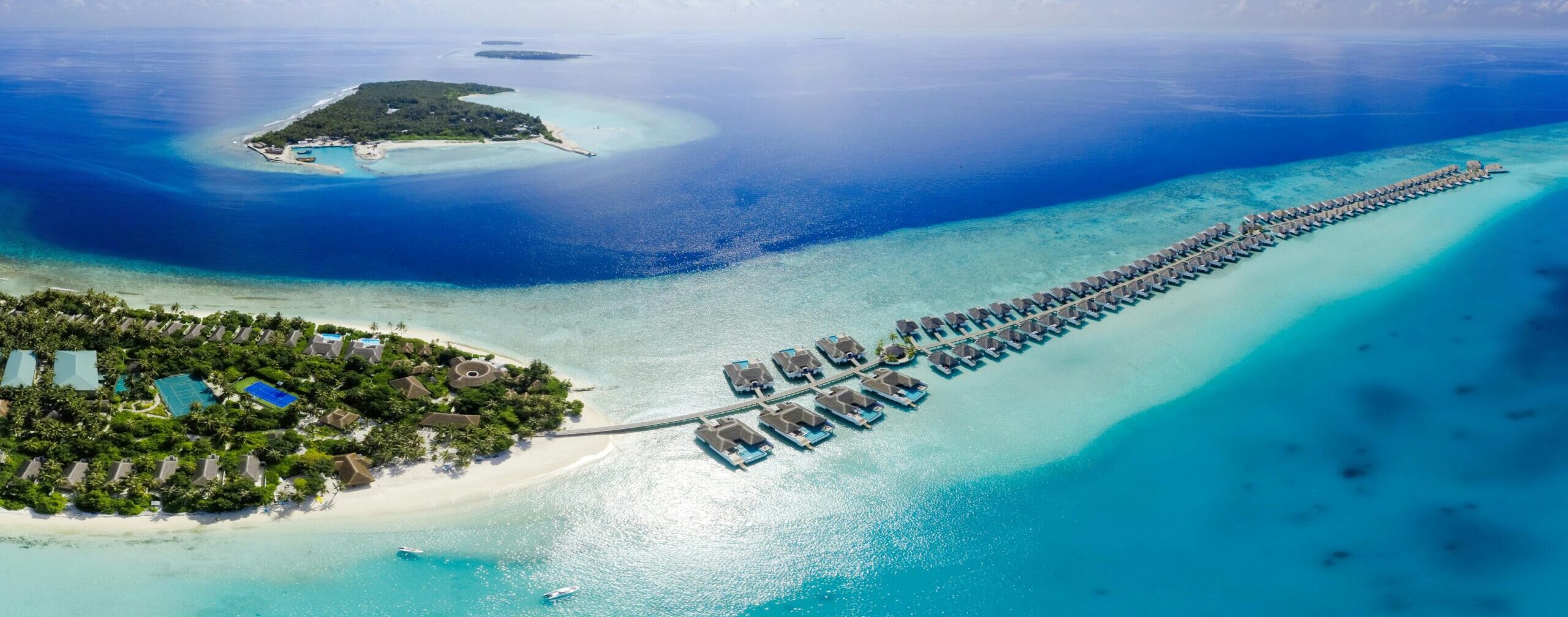 Luxury overwater bungalows in the Maldives at a five-star all-inclusive resort surrounded by turquoise waters and coral reefs.