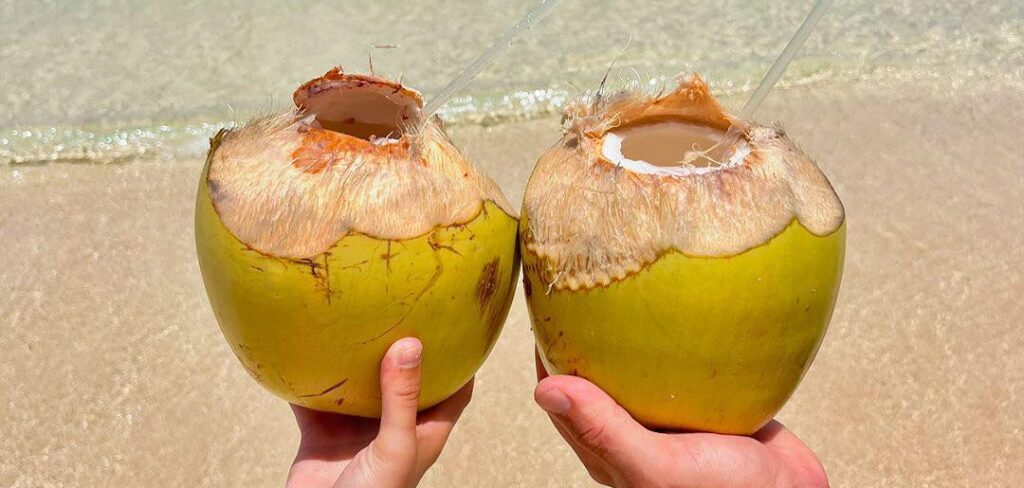 Loving couple holding their drinks out for a special photo op at a caribbean beach resort